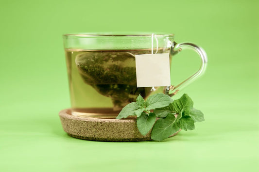 Sachet de thé vert dans une tasse en verre - infusion au pandan